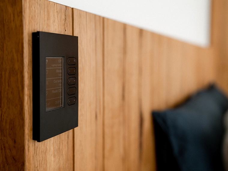 Wall-mounted C-Bus black control panel with options for lighting, blinds, curtains, and room off.