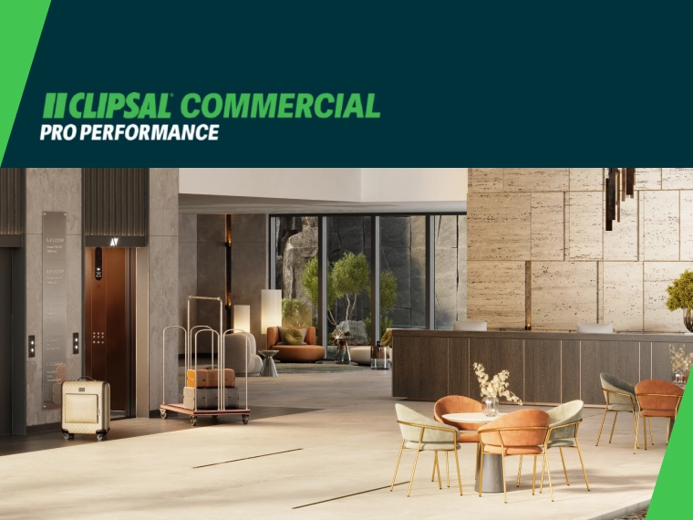 Modern commercial lobby with elevators, stone walls, large windows and seating area.