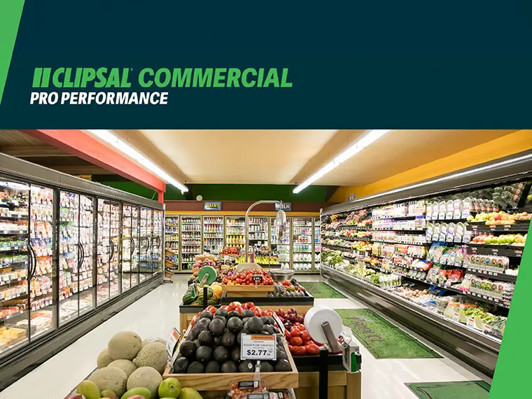 Grocery store aisle with fresh produce display and refrigerated shelves.