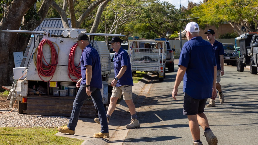 Polar Industries team standing together beside service vehicles at a construction site.