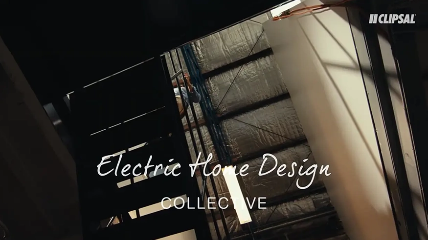 Neil Hipwell walking through an industrial staircase, overlaid with Electric Home Design Collective by Clipsal branding.