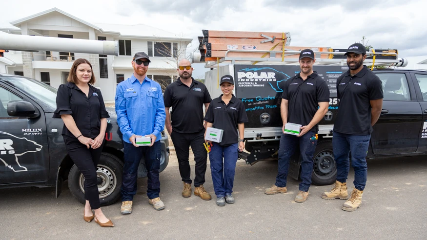 Polar Industries team standing together beside service vehicles at a construction site.