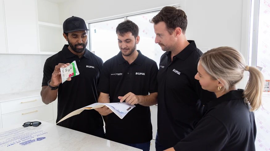 The crew of Polar Industries wearing Clipsal shirts while reviewing the electrical plans