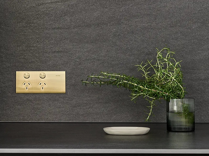 A Clipsal Solis T Series power outlet in Brushed Brass.