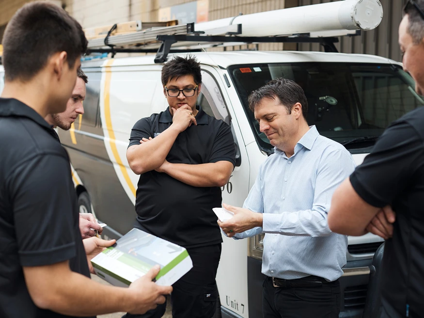 A group of electricians discussing Clipsal products.
