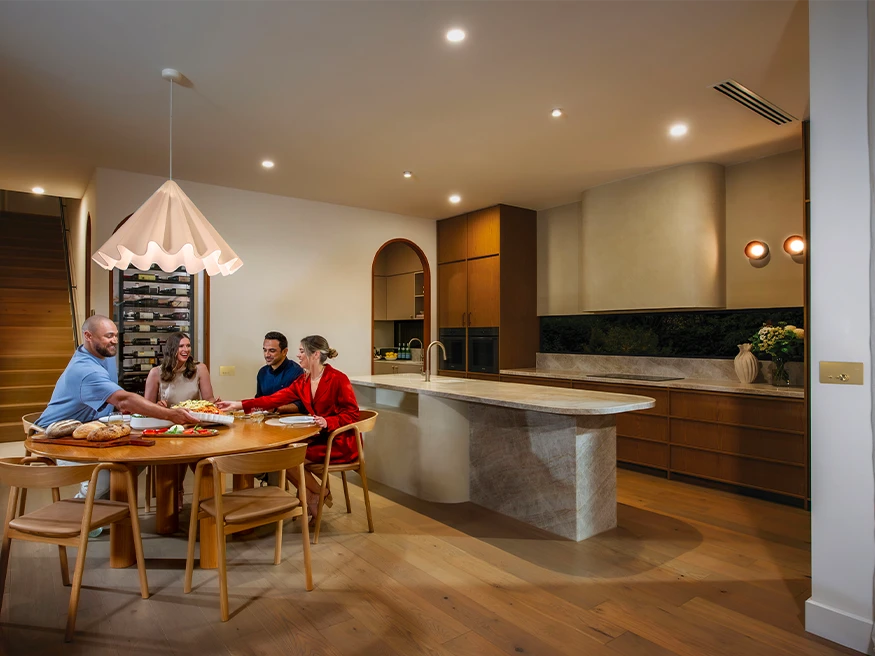 A family dining together in a stylishly designed kitchen featuring Clipsal products.