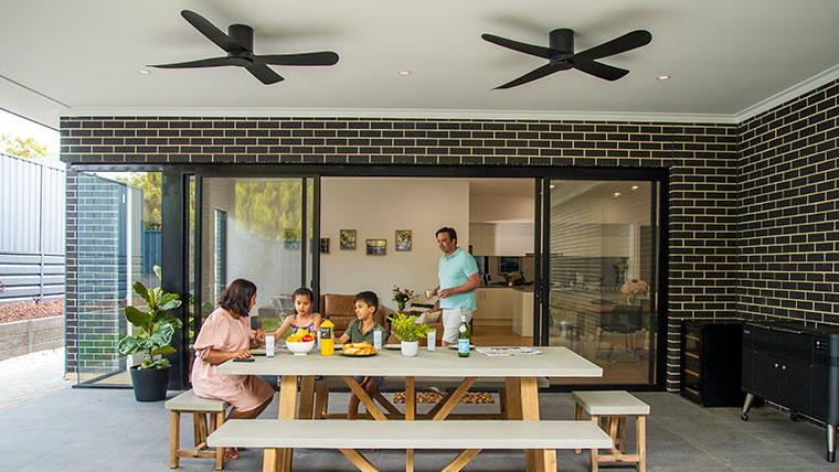 Family at table with ceiling-mounted Clipsal Zen Fan