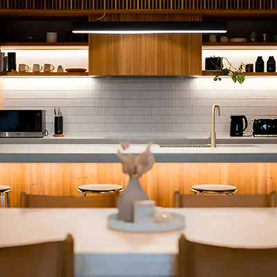 Warm, modern kitchen with wood cabinetry and under-cabinet lighting.