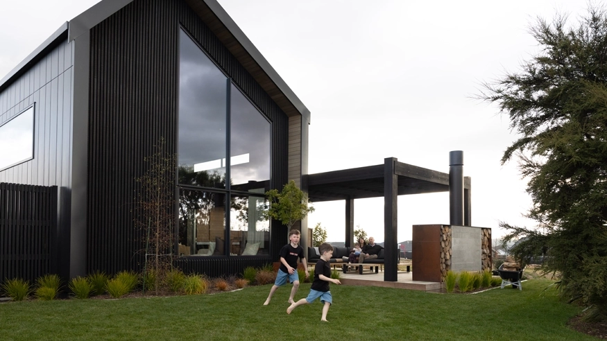 A pair of children playing in the garden of their family home.