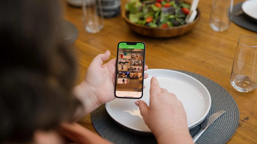 A homeowner configuring Wiser by SE app Moments on their smartphone.
