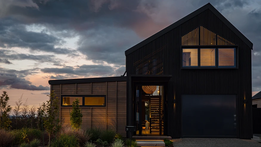 A well-lit modern home exterior at dusk.