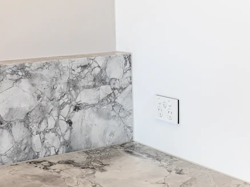 Saturn Zen double power point with an extra switch on the wall beside the marble-patterned countertop.