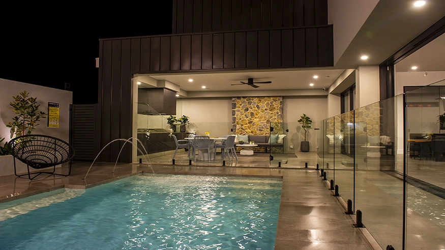 A well-lit holiday home poolside area.