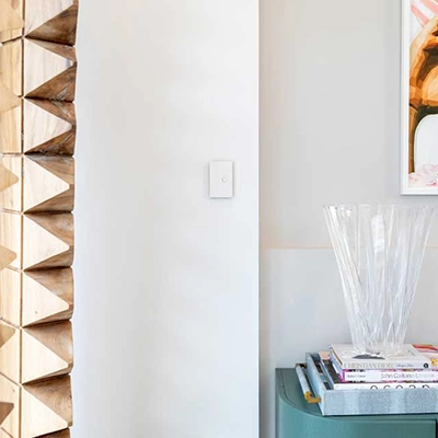 A modern furnished hallway with a white Clipsal switch on the wall.