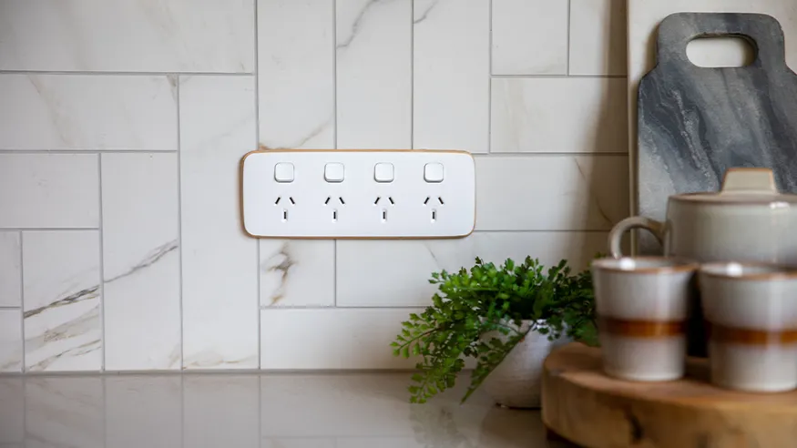 A Clipsal Iconic Essence power outlet installed on a ceramic backdrop.