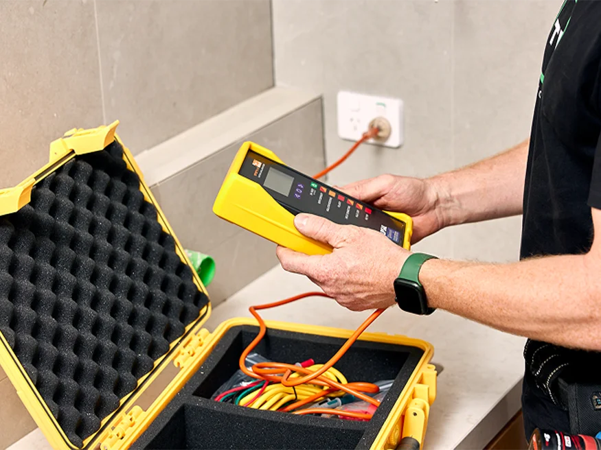 An electrician examining logs on a Spark-e-mate device.