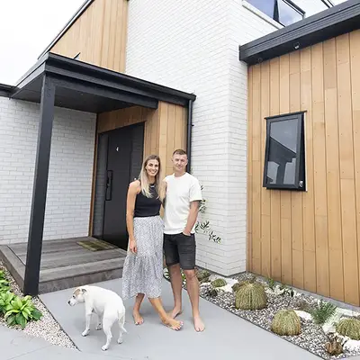 Homeowners and builders Ben and Quinn standing in front of their home, designed with Clipsal Electric Home Design.