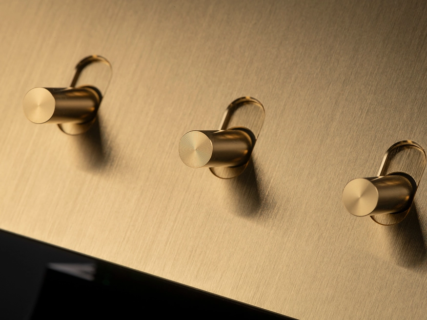 A close up of a Clipsal Solis T Series Brushed Brass switch.
