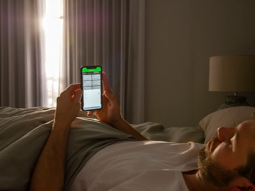 A homeowner controlling his home with a smart home automation app.