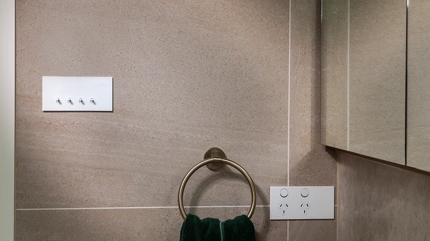 A Clipsal Solis™ white switch and socket installed on a wall.