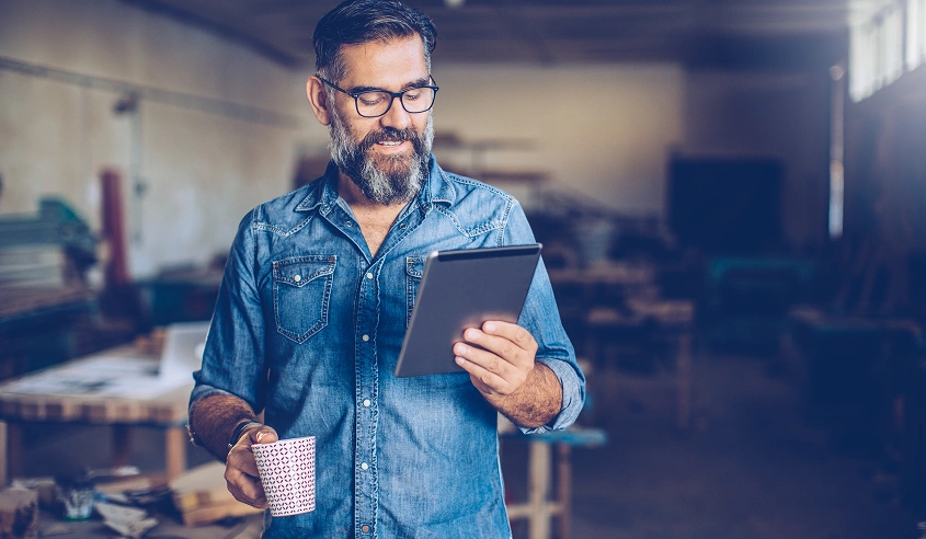 A wholesaler catching up on Clipsal Distributor News on his smartphone.