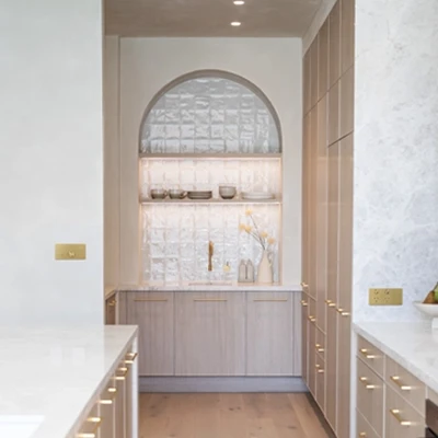 A modern kitchen featuring premium new range of electrical switches and power points complemented on white cabinets with elegant gold hardware.