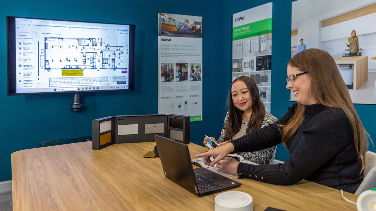 A Clipsal Design Service consultant showing Clipsal product options to a client.