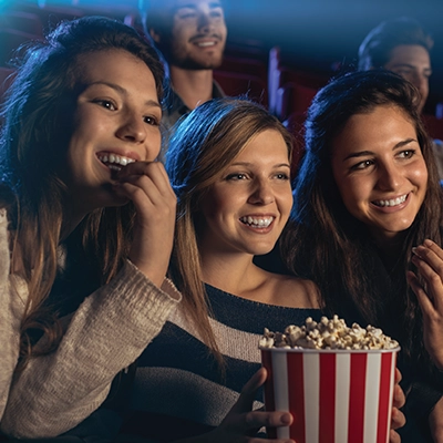 A group of teenagers watching a movie in a cinema.