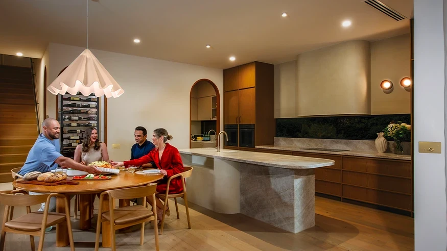 A family dining together in a stylishly designed kitchen featuring Clipsal products.