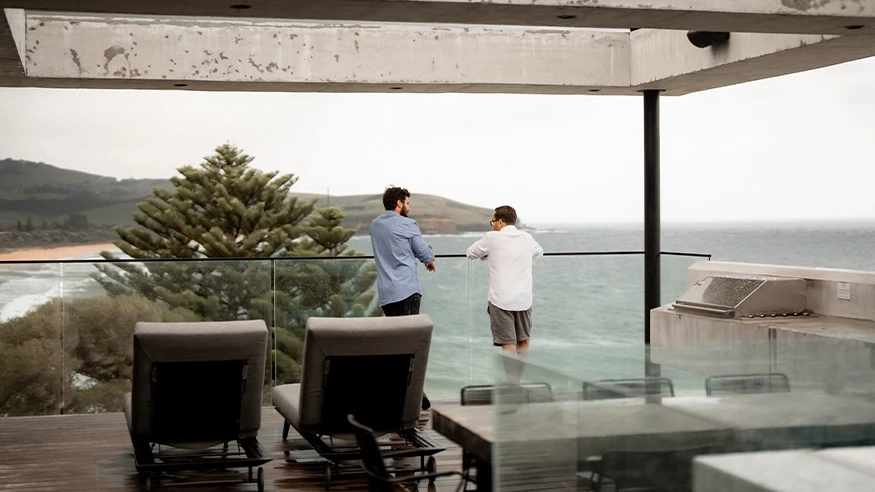 Neil and Tom looking out the oceanfront balcony of Bunker House. 