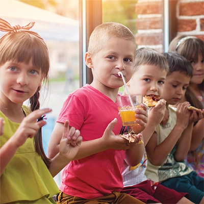 A group of children drinking orange juice.