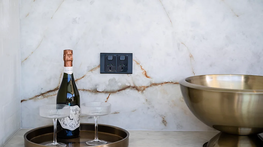 Iconic Styl on a marble splashback beside champagne glasses and a bottle.
