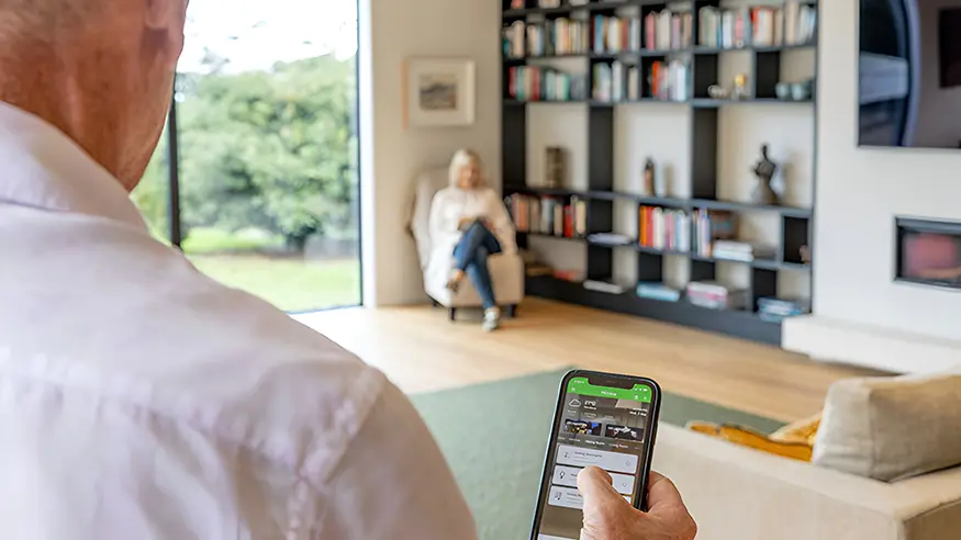 A homeowner using Clipsal Wiser Smart Home Automation on their phone.