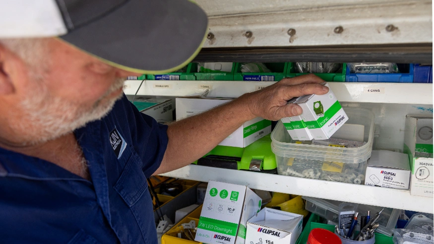 Kevin from KJN Electrical picks Clipsal products off a shelf.