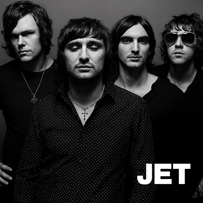 Australian rock band Jet, four members standing against a dark background with 'JET' in white text.