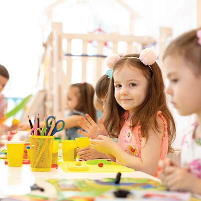 Children sitting at a table doing arts and crafts.