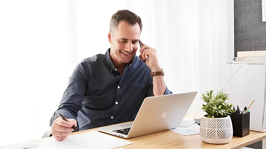 A man reading the Clipsal mailing list newsletter on his laptop.