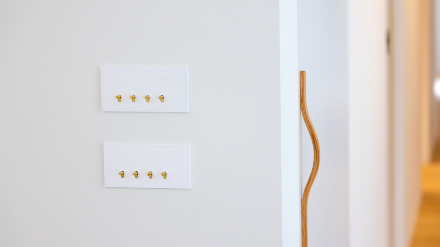 A white wall displaying two switches for controlling lights or appliances.