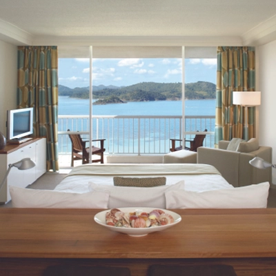Hotel room with ocean view, balcony, and modern furnishings.