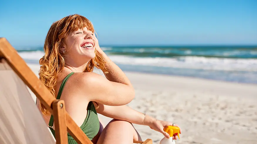 Smiling woman relaxing on a sunny beach.