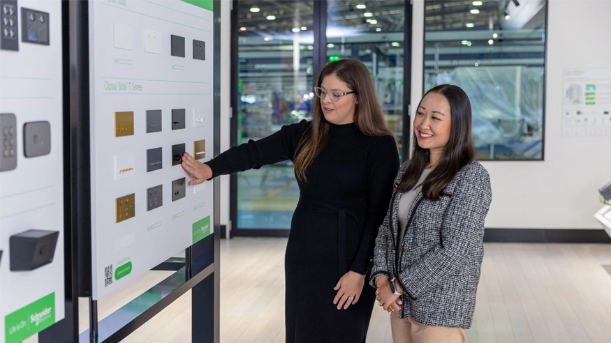 A Clipsal Design Service consultant showing a client some Clipsal Solis products on a display board.