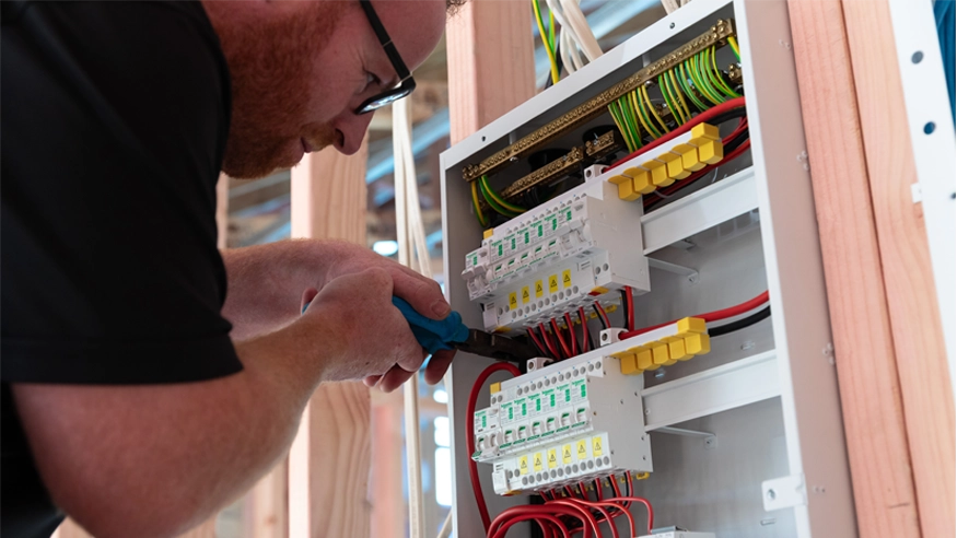 An electrician installing surge protection devices in a residential switchboard.